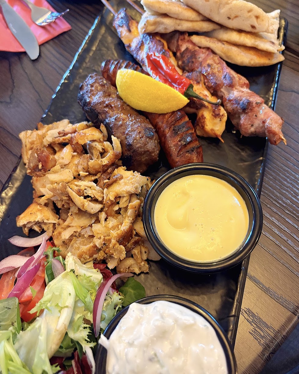 Greek Mixed Grill platter from Greek Theory in Falkirk, featuring souvlaki, gyros, 
sausage, and kebab with fries, pita, and tzatziki